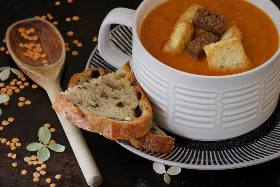 Tomato and lentil soup with croutons and rustic bread