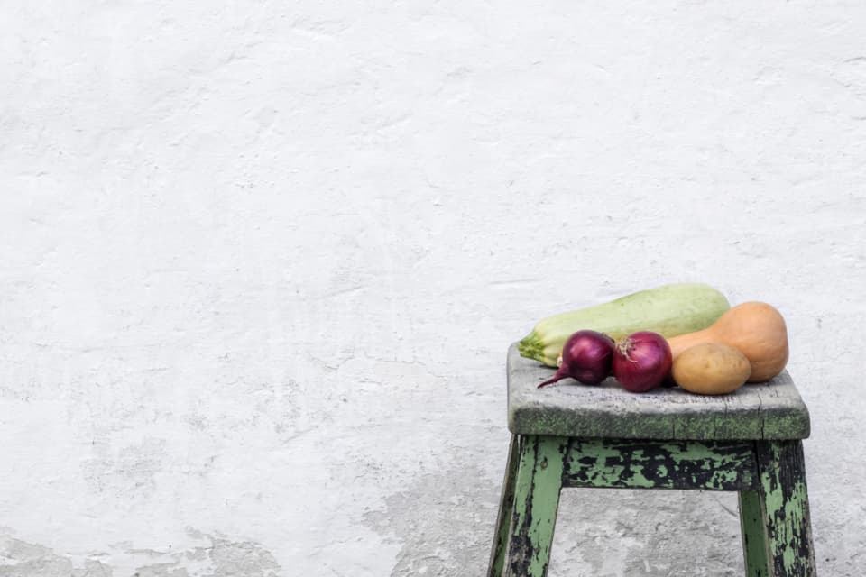 Fresh vegetables resting on a rustic stool