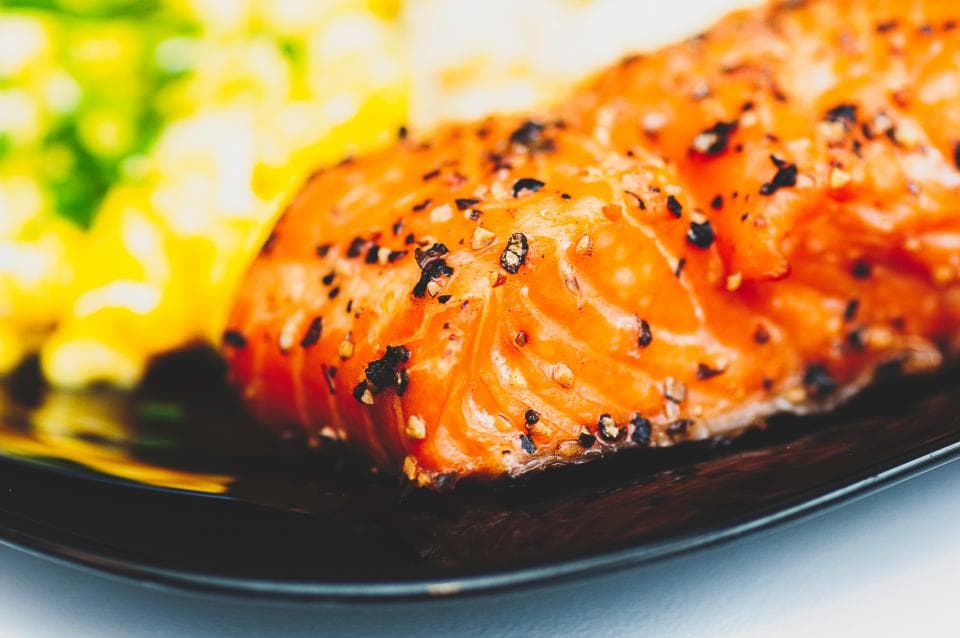 Cracked-pepper salmon fillet over a bright vegetable medley